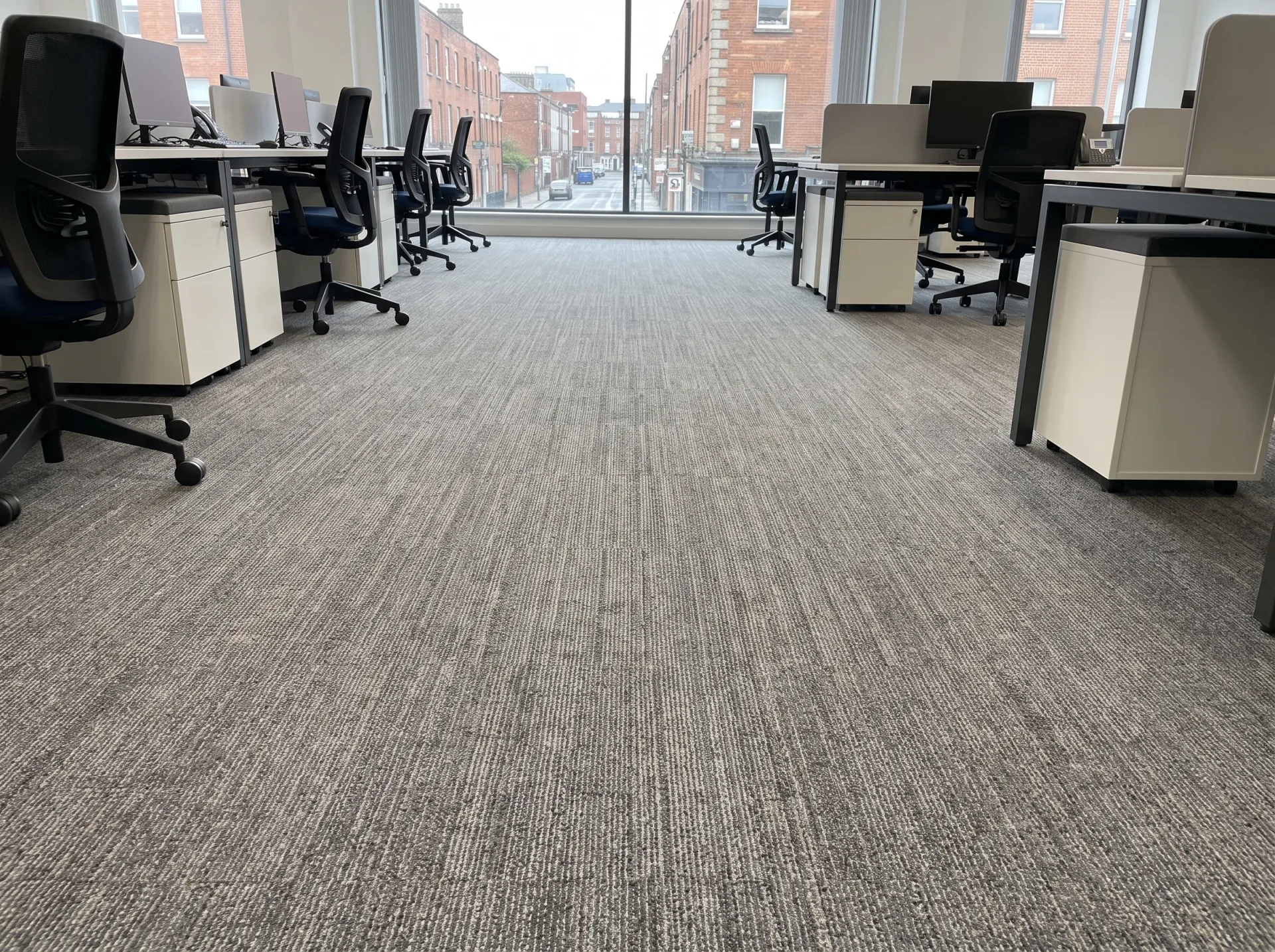 Modern commercial office carpet with workspace desks and ergonomic seating