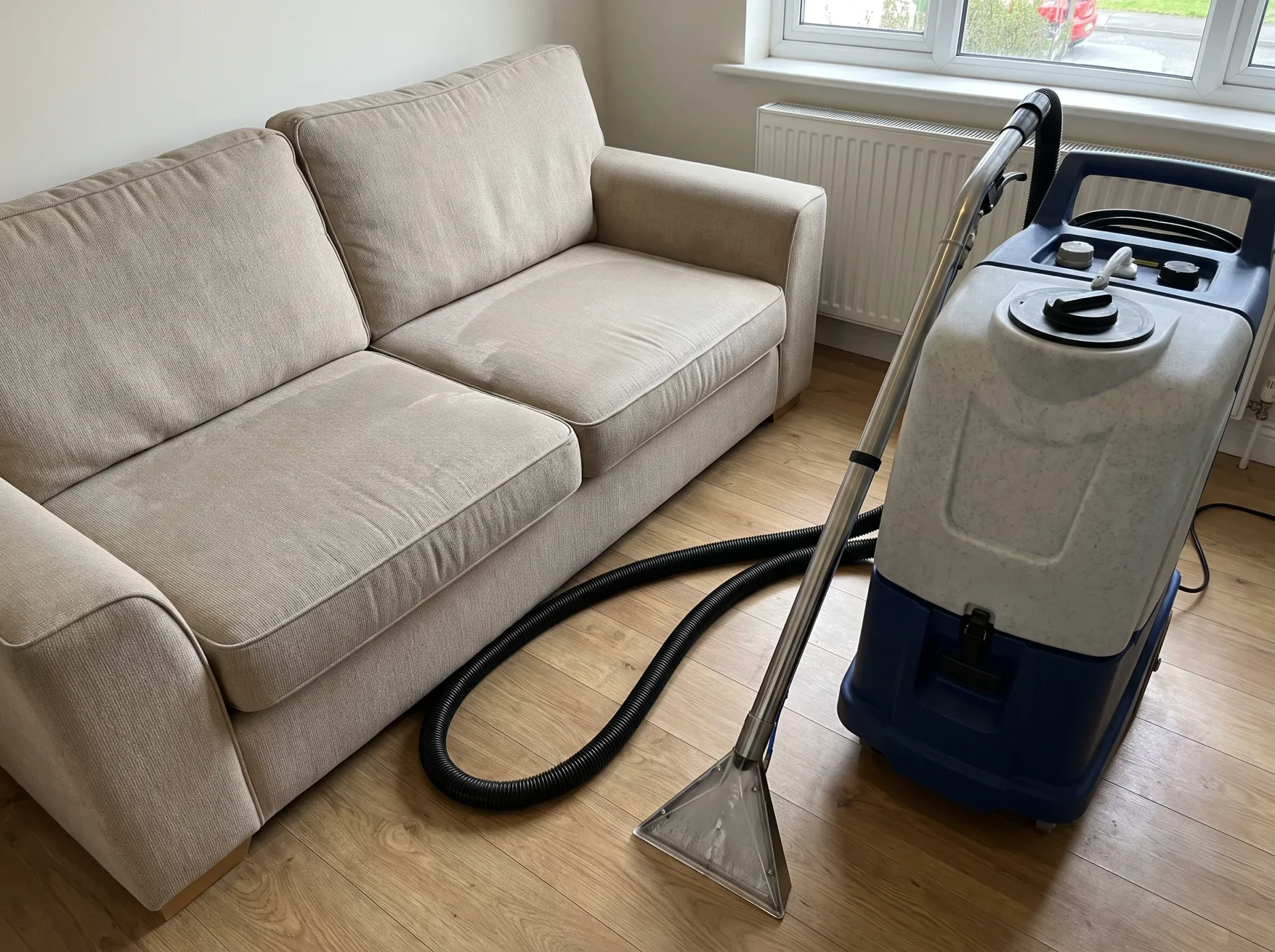 Professional sofa cleaning in progress using hot water extraction equipment