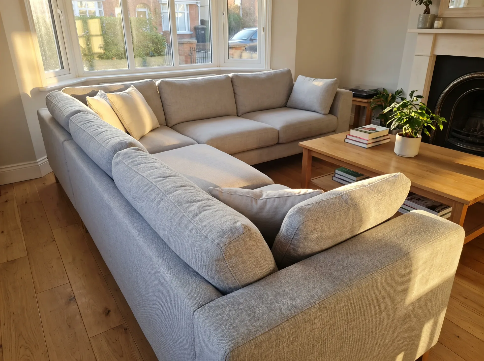 Clean light gray upholstered L-shaped sofa in bright modern living room with fireplace